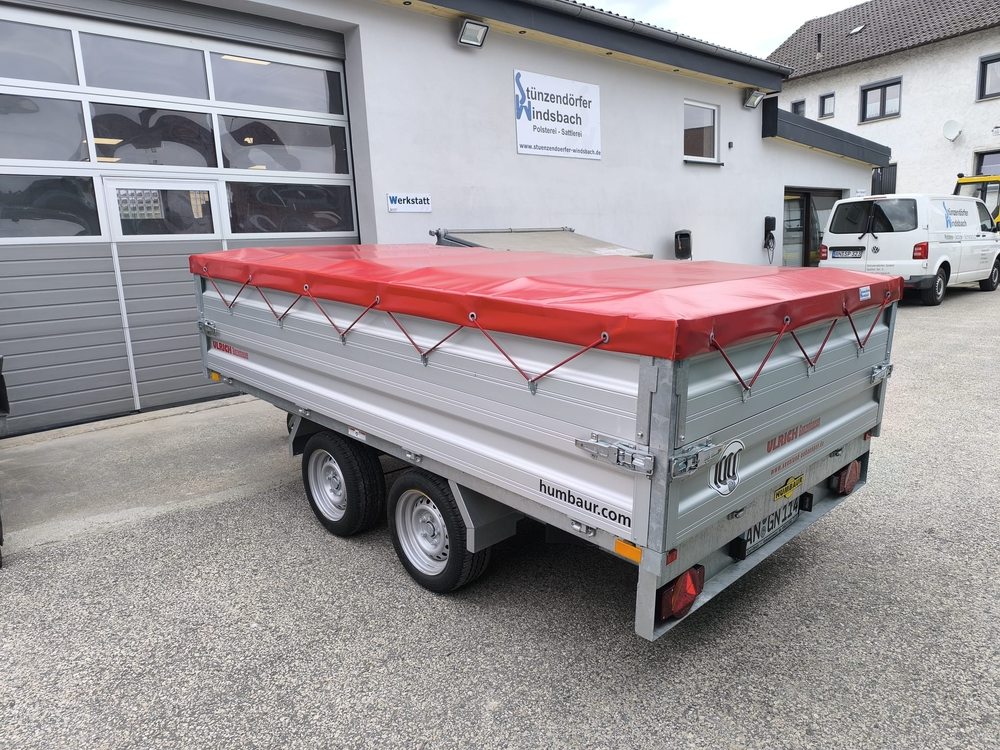 Anhänger mit roter Abdeckplane vor dem Firmengebäude von Stünzendörfer in Windsbach